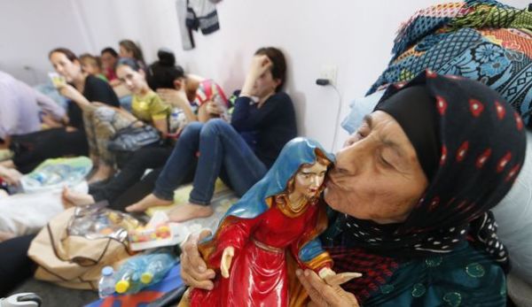 une-femme-chretienne-irakienne-fuyant-la-violence-du-village-de-qaraqush-dans-le-nord-du-pays-embrasse-une-statue-de-la-vierge-dans-un-centre-de-refugies-d-arbil-le-27-juin-2014_4944507